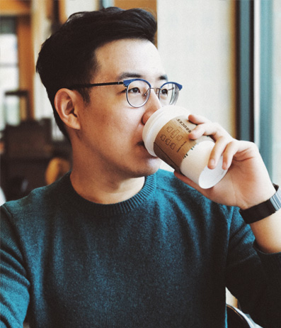 Young Asian Man With Glasses Drinks From Starbucks Coffee Cup