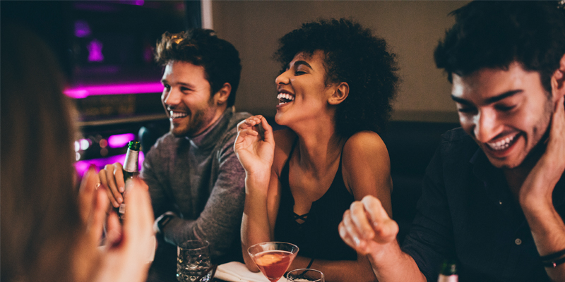 A Group of Friends Laughs and Enjoys Their Time Together Over Dinner at a Restaurant