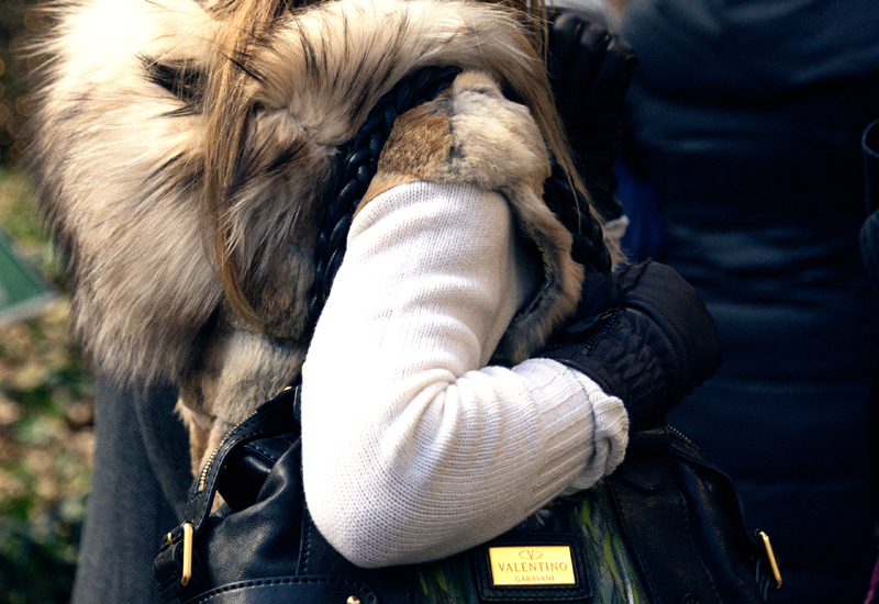 Stylish Woman in Brown Floppy Hat With Fur Vest Stands With African American Man on Sidewalk