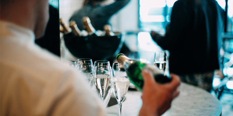 A Bartender Pours Out Several Glasses of Champagne