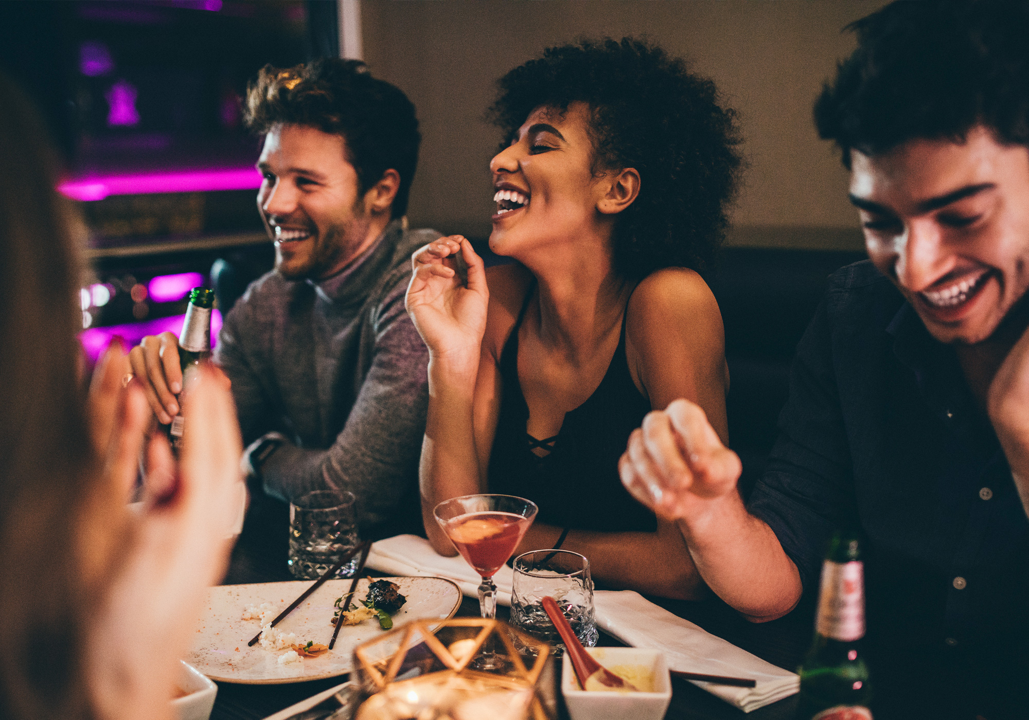 A Group of Friends Laughs and Enjoys Their Time Together Over Dinner at a Restaurant